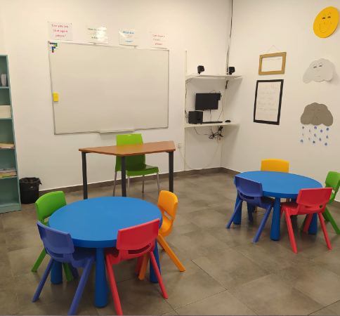 Calse con mesas y sillas de colores academia